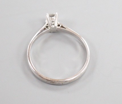 A modern 18ct white metal and solitaire emerald cut diamond set ring, size K, gross weight 2 grams